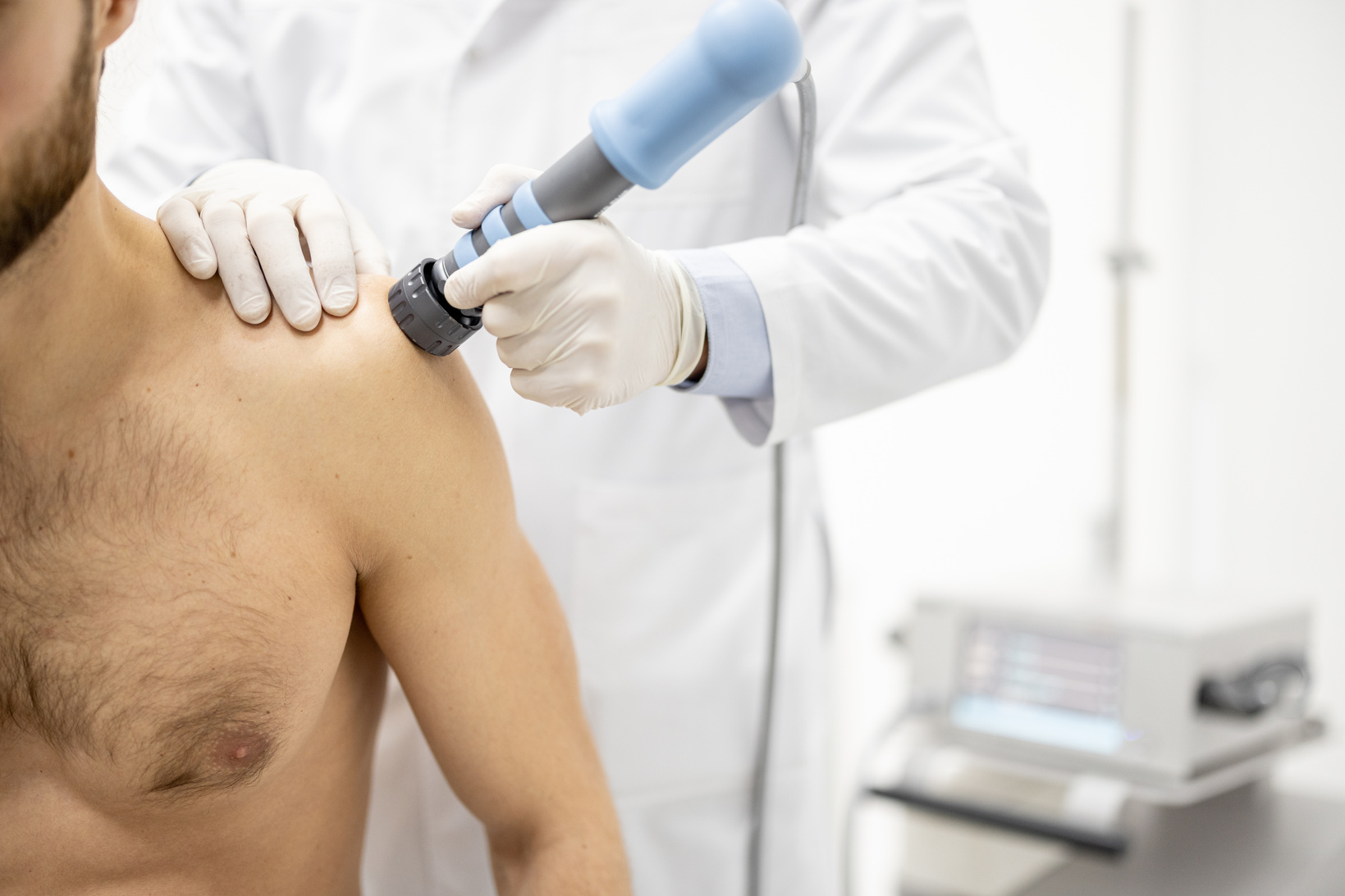 Doctor Applies Shock Wave Therapy on Man's Shoulder